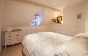 a bedroom with a white bed and a window at Hook Cottage in Chipping Campden