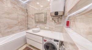 y baño con lavadora y lavamanos. en PEARL PREMIUM APARTMENTS 2, en Kiev