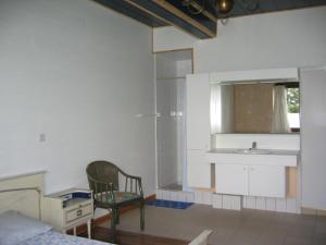 uma cozinha com um lavatório e uma cadeira num quarto em Vakantiehuis 10 personnes em Queyssac