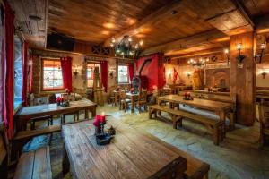 widok na restaurację z drewnianymi stołami w obiekcie Pokoje w Oberży Czarny Groń w mieście Rzyki