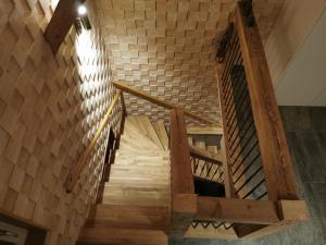a wooden spiral staircase with a brick wall at Jupi Hüsli in Göschenen