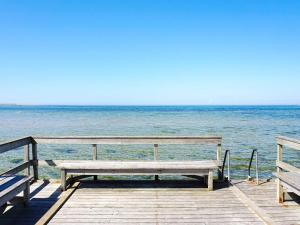 a bench sitting on a dock near the ocean at 4 person holiday home in Visby in Visby