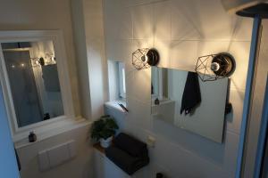 La salle de bains est pourvue de 2 lumières sur le mur et d'un miroir. dans l'établissement Goldene Feder, à Rostock