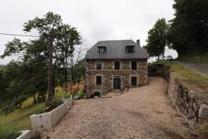 an old stone house on the side of a road at GITE pour famille in Saint-Clément
