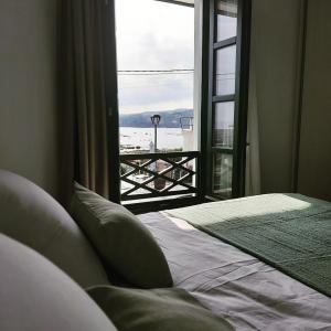 a bedroom with a window with a view of the ocean at Apartamentos El Muelle Comillas in Comillas