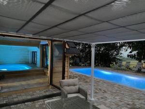 un patio cubierto con una silla junto a la piscina en Villa Bialka & Spa, en Groń