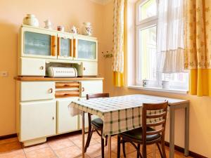 a kitchen with a table and chairs and a hutch at Authentic and cosy holidayhome with big beautifull garden in Altentreptow