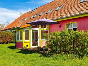 a colorful house with an umbrella in the yard at Authentic and cosy holidayhome with big beautifull garden in Altentreptow