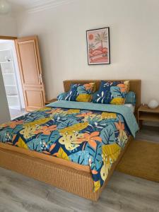 a bedroom with a bed with a colorful comforter at le Garden Cocoon in Istres