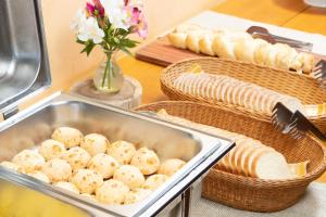 una mesa con cestas de pan y una bandeja de comida en Pousada Das BergHaus Turismo Rural e Cervejeiro en Extrema