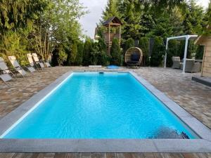 una piscina azul con sillas y un cenador en Villa Bialka & Spa, en Groń