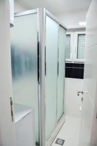 een badkamer met een douche en een glazen deur bij Uvac lake "FF" in Sjenica