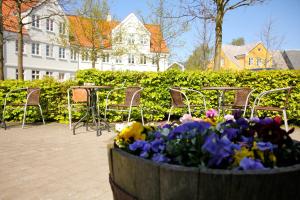 a barrel filled with flowers and tables and chairs at Hotel Ribe in Ribe