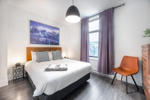 a bedroom with a bed and a chair and a window at Montreal Styled 2 BR Apartment on St-Denis Street in Montréal
