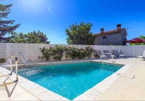 a swimming pool in a backyard with a fence at Pepe&Lynn in Višnjan