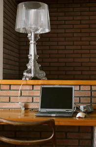 un ordinateur portable assis sur une table avec une lampe dans l'établissement Carlina Lodge, à Biarritz