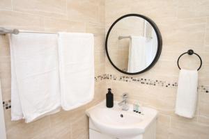 Un baño con un lavabo blanco y un espejo. en Northcote Lane Apartments - By Property Promise, en Cardiff 16 fotos más