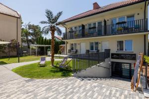 a house with a patio and a palm tree at Amber Tiger Villa in Pobierowo