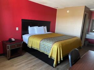 um quarto de hotel com uma cama e uma mesa em Deluxe Inn em West Memphis