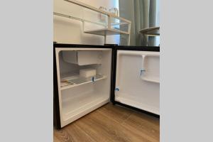 un réfrigérateur vide avec une porte ouverte dans une pièce dans l'établissement cute studio rom, à Mons