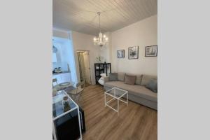 uma sala de estar com um sofá e uma mesa em cute studio rom em Mons