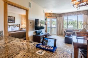 a living room with a room with a bed and a laptop on a counter at Juniper Springs Lodge #413 - Luxury Ski in Ski out! 2 Bedroom in Mammoth Lakes