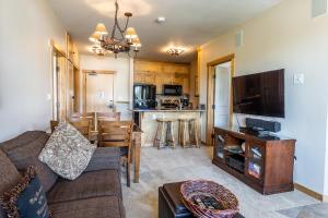 a living room with a couch and a dining room at Juniper Springs Lodge #413 - Luxury Ski in Ski out! 2 Bedroom in Mammoth Lakes