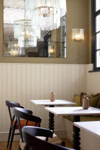 a restaurant with white tables and chairs and a chandelier at The Yard in Bath Hotel in Bath