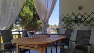 a wooden table and chairs on a patio at Politakis Apartment in Keramoti +29 photos