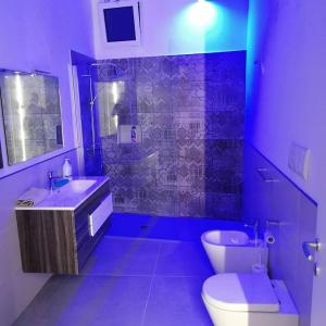 a purple bathroom with a toilet and a sink at Dimora Felline in Giurdignano +11 photos