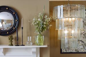 a vase of flowers on a table with a mirror at The Yard in Bath Hotel in Bath