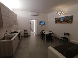 a kitchen and living room with a table and chairs at Dimora Felline in Giurdignano
