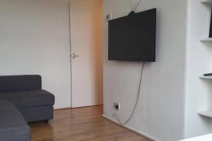 a living room with a couch and a television on a wall at Central 1 BR Apartment *Zone 1* Elephant and Castle in London