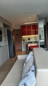 een woonkamer met een bank en een keuken bij Condomínio Vista Azul -CASA DOS CARDOSO in Domingos Martins