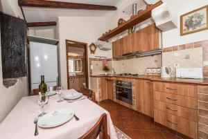 una cocina con una mesa con copas de vino. en Guest House Dragutinovic en Perast