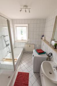 La salle de bains blanche est pourvue d'une baignoire et d'un lavabo. dans l'établissement Ferienwohnung Chiemsee, à Unterneukirchen