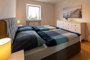 a bedroom with a bed and a dresser and a window at Ferienwohnung Chiemsee in Unterneukirchen