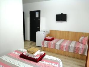 a bedroom with two beds and a tv on the wall at Casa di Sonia in Eforie Nord +28 photos