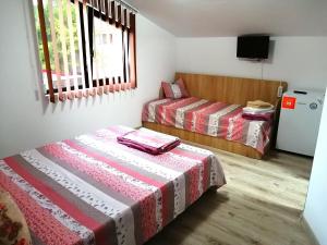 a room with two beds and a television in it at Casa di Sonia in Eforie Nord