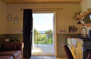 a living room with a door open to a patio at Coorie In in Kilmore