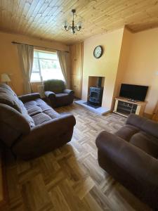 a living room with a couch and a tv at Heather Cottage, Creeslough in Creeslough