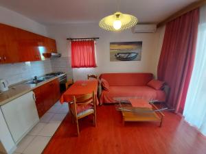 a living room with a red couch and a table at Apartments & Rooms Nensi in Baška