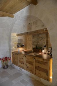a kitchen with a sink and a stone wall at Dimore Barsento in Alberobello
