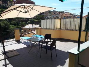 een patio met een tafel en stoelen en een parasol bij Il Cavalluccio Marino in Manarola