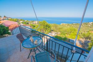 a balcony with a table and chairs and the ocean at Elena Studios in Athani