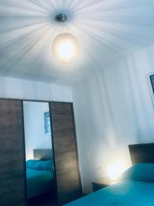 a bedroom with a mirror and a bed and a light at Ikar Apartment in Ika