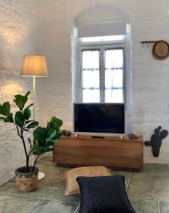 a living room with a flat screen tv on a table at NIREAS STONEHOUSE IN APOLLONIA SIFNOS in Sifnos