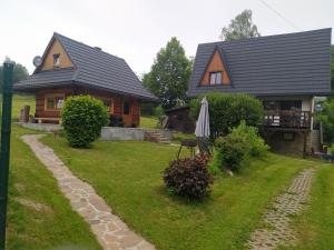 a house with an umbrella in front of a yard at Domek Wałacha in Istebna