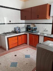 a kitchen with a stove and a microwave at Almarsa4 in Al Hoceïma