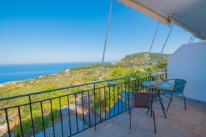 a balcony with a table and chairs and the ocean at Elena Studios in Athanion